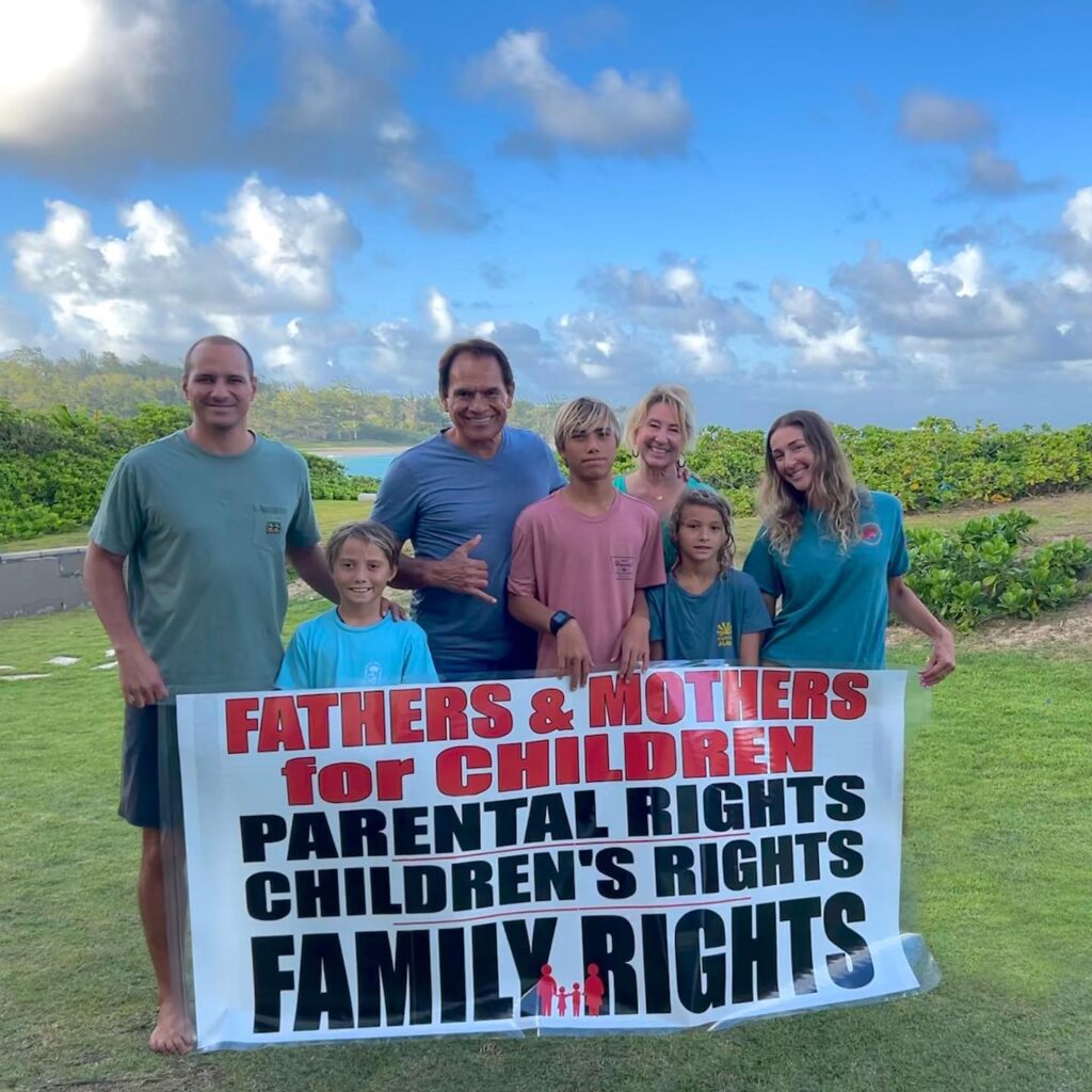 A family holding a Fathers and Mothers for Children banner